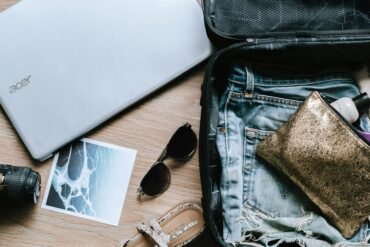black DSLR camera near sunglasses and bag