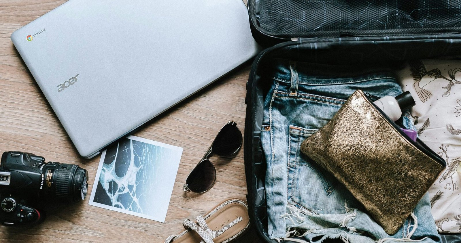 black DSLR camera near sunglasses and bag